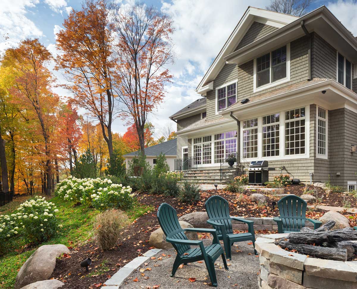 Custom designed home's back yard with fire pit and stone steps and walkway