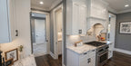 Wexford prep kitchen with a gas range, white cabinetry, and stone countertops.