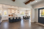 Modern kitchen and dining area with wooden floors and white walls.