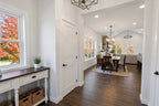 Foyer with a view of a dining area through a doorway, featuring a console table, window, and door.
