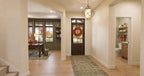 Alder Glen foyer with a glazed wood front door, geometric pendant light and openings to the office and powder room.