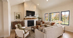 Alder Glen vaulted great room with a floor-to-ceiling stone fireplace, neutral sofas and large rear-facing windows.