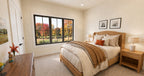 Alder Glen front bedroom with a wood bed, matching nightstands, neutral bedding and a large black-framed window.