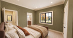 Alder Glen rear bedroom with muted green walls, an upholstered bed and openings to the hallway and shared bathroom.