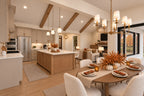 Dining room with autumn table settings, looking across the wood kitchen island toward the great room fireplace.