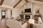 Willow Cove great room facing the stone fireplace and foyer, with cream seating arranged around a wood coffee table.