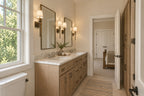 Willow Cove Jack and Jill bathroom with a wood double vanity, two mirrors, wall sconces and a large window.