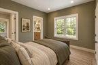 Willow Cove rear bedroom with olive-green walls, neutral bedding and open doorways to the shared bathroom and hallway.