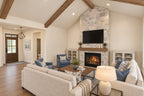 Oak Haven great room facing the stone fireplace and foyer, with cream sofas and blue armchairs around a wood coffee table.