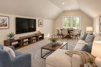 Oak Haven bonus room with a cream sectional, blue armchair, wall-mounted television and a game table beneath the far window.