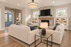 Great room seating facing the fireplace with the blue front door visible through the foyer.