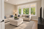 Office and living room shown as a sitting room with a sectional sofa and broad front windows.