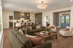 Great-room rendering with sofa seating, an open kitchen and a view toward the front entrance.