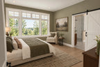 Main-level primary-bedroom rendering with a large window and a sliding bathroom door.