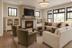 Great-room rendering with seating facing the fireplace beside broad windows.