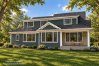 Rear exterior rendering with dark siding, upper-story windows and a covered porch with seating.