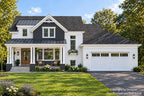 Front elevation of Ferncroft a farmhouse design with a timber-accented gable, covered porch, white siding and a two-car garage.
