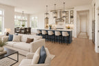 View from the great-room seating toward a navy kitchen island, white cabinetry and the window-lined dining area.
