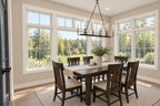 Dining area with a dark wood table, upholstered chairs, a lantern chandelier and windows on two sides.