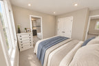 Upstairs bedroom with neutral bedding, a double-door closet and an adjoining bathroom.