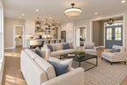 Great-room seating with a wood coffee table, open kitchen and blue double front doors beyond.