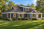 Rear-left exterior of a Craftsman house plan with charcoal lap siding, a broad upper dormer, a window-lined dining area and covered back porch.