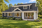 Rear-right exterior of a Craftsman house plan with an upper shed dormer, white trim and grouped columns around the covered back porch.