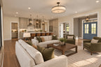 Great room seating faces the open kitchen island, with a blue front door visible beside the foyer.
