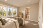 Upstairs bedroom with green bedding and a large window, looking toward an adjoining bathroom.