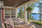 Daytime rendering of the covered front porch with a rocking chair, hanging basket and lake view beside the screened porch.