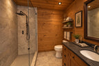 Bathroom rendering with a glass shower enclosure, stone-look tile, a wood vanity and a dark countertop.