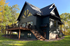Angled rear cottage rendering with a raised deck, outdoor stairs and walkout lower-level doors.