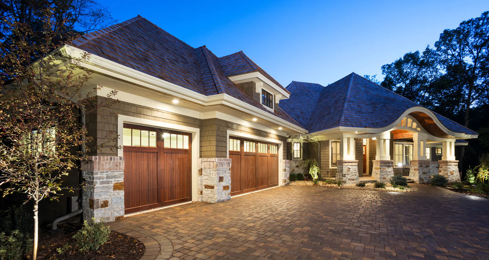 craftsman styled custom house with shake siding, stone accents, and a 3 car garage